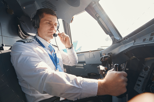 Pilot bringing microphone of headset to his mouth