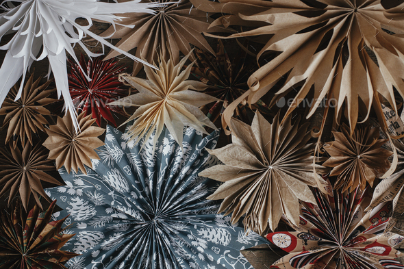 Stylish Christmas stars flat lay on rustic background. Beautiful handmade stars from wrapping paper