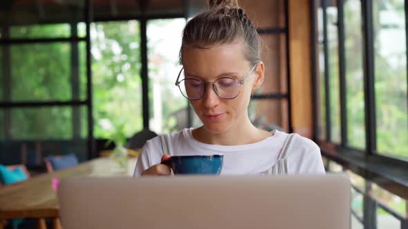 Adult woman in glasses work on laptop 