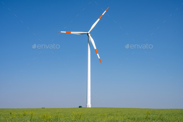 Modern wind turbine in front of a blue sky - Stock Photo - Images