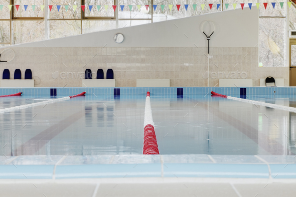 Indoor swimming pool, red and white dividers in swim lanes, surface view.