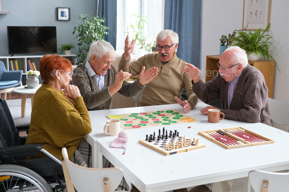 Senior friends playing board game together