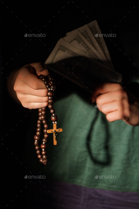 Christian woman with wooden cross necklace and money.