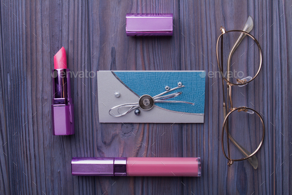 Makeup cosmetics kit over wooden background.