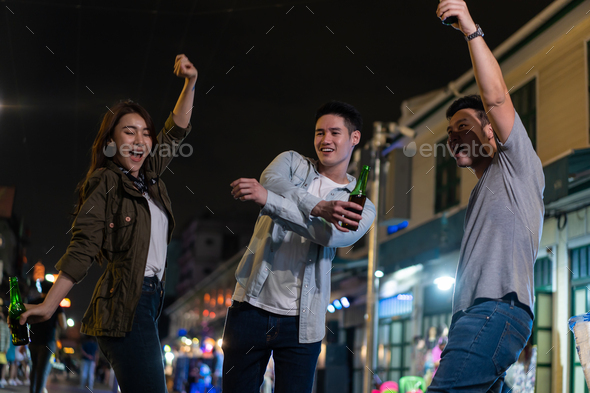 Asian attractive people drinking alcohol, dancing and hangout party at night on the road