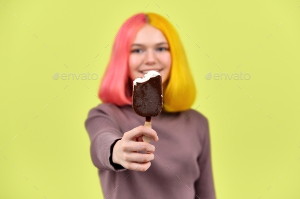 Half-eaten chocolate ice cream in a young woman\'s hand close-up