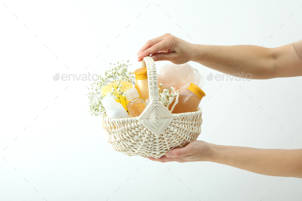 Concept of gift with basket of cosmetics on white background