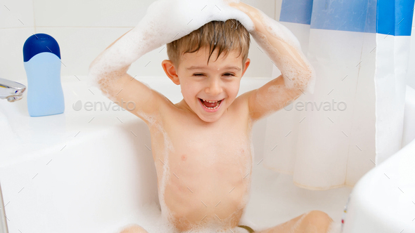 Happy funny little boy washing his head with shampoo while taking bath at  home. Concept of child Stock Photo by kryzhov