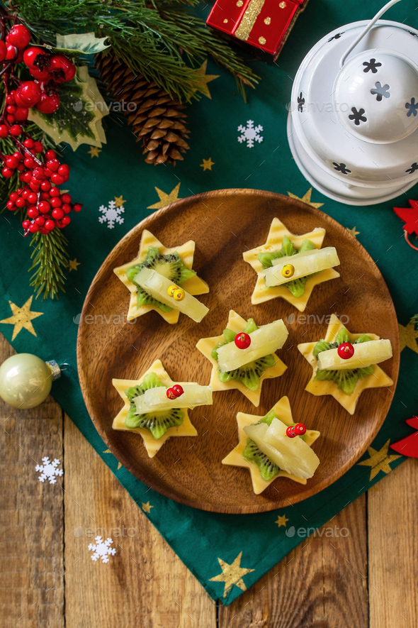 Fruit canapes with cheese, kiwi and pineapple. Stock Photo by khramovaelena