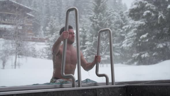 Close-up of a man stepping out of a pool at a luxury spa resort. alt