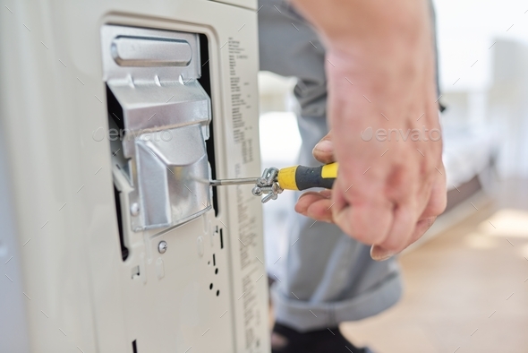 Installing an air conditioner in an apartment office, close-up of an technician hands