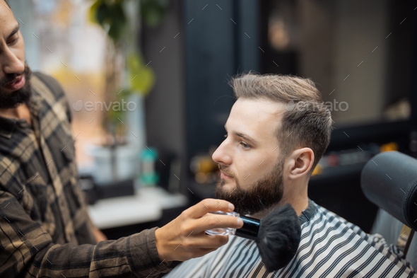 The master removes the remaining hair from the client with a brush