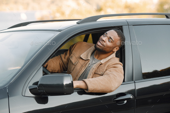 Portrait of nervous young black man sitting in his car