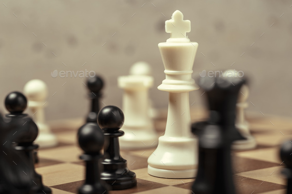 Premium Photo  Closeup of chess pieces on the chessboard under the lights  with a blurry background