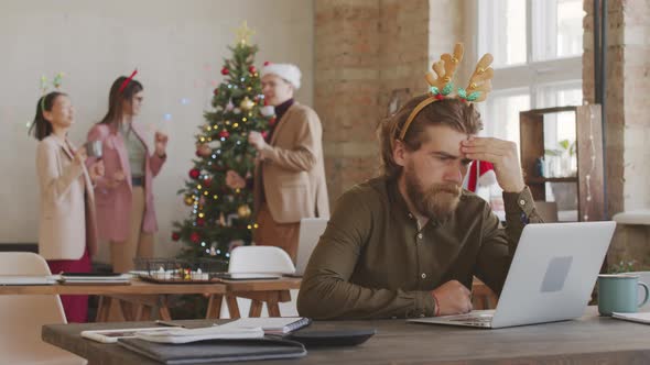 Overworked Businessman Working in Office on Christmas alt