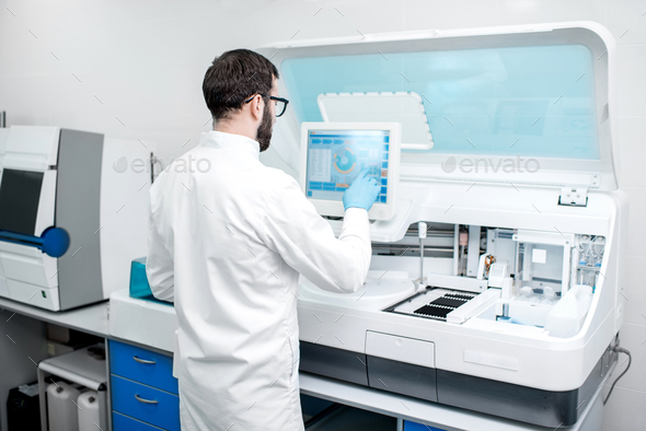 Laboratory assistant working with medical analizer machine - Stock Photo - Images