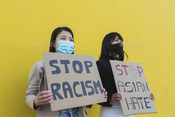 Two asian young women during no racism protest - Stock Photo - Images