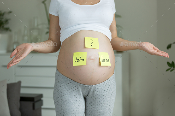 Concept of choosing baby's name. Pregnant woman with names - Stock Photo - Images