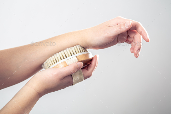 Female hands massage with a massage brush.