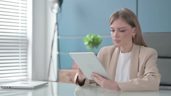 Businesswoman Celebrating Success on Tablet in Office alt
