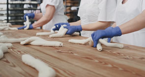 Professional Bakers Forming Pieces of Long Dough alt