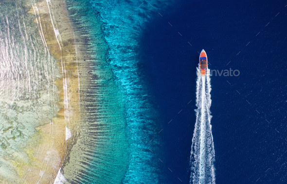 Fast boat on the sea. Aerial view of luxury floating boat on blue water at sunny day.