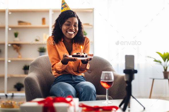 Black Female With Birthday Cake Video Calling Via Cellphone Indoors