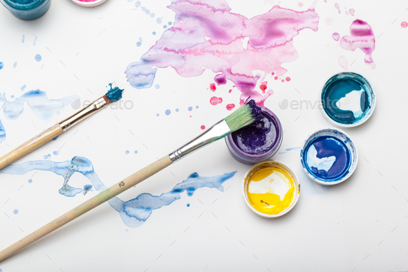 splashes of watercolor paint and painting supplies close up Stock Photo by  FabrikaPhoto
