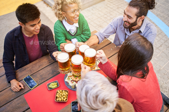 Friends drinking beer at terrace outdoors on weekend. Friendship concept