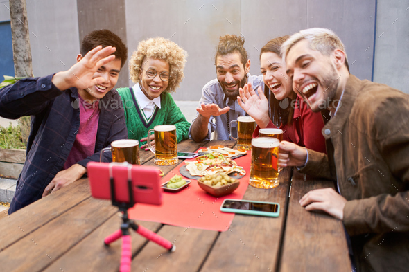 Group of people taking selfie photo of celebration with friends in outdoors bar to share
