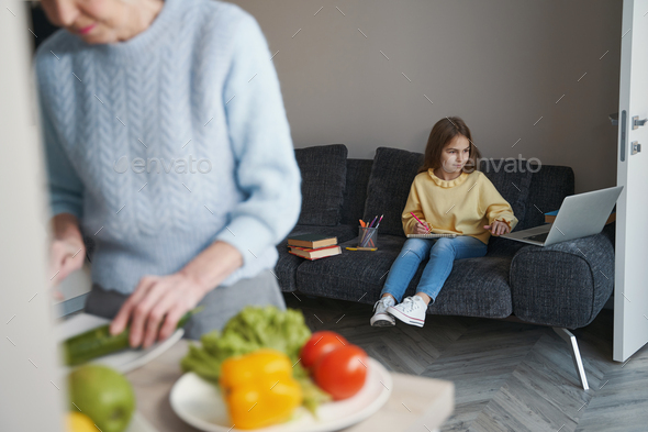 Caring elderly lady cooking lunch for her lovely granddaughter - Stock Photo - Images