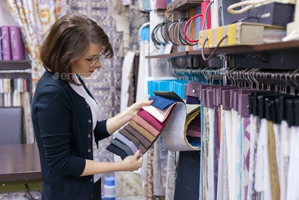 Woman designer, decorator chooses fabrics for curtains