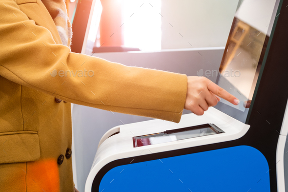 Lady passenger uses self service kiosk to checkin for flight