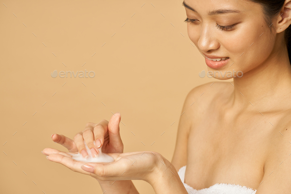 Close up portrait of lovely young woman ready to apply gentle foam facial cleanser