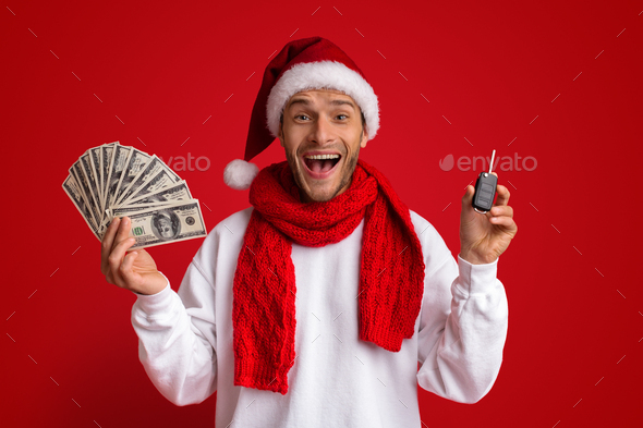 Xmas Bonus. Excited Man In Santa Hat Holding Car Key And Cash