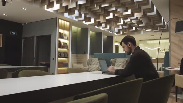 Young Focused Handsome Male Businessman Working on a Laptop alt