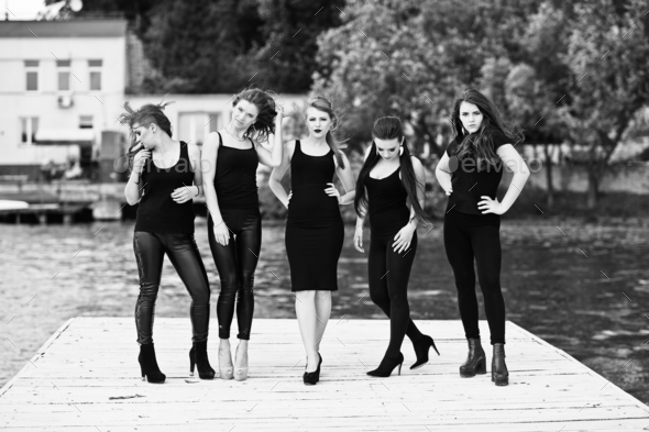 Five beautiful young sexy girls models in black tight dress posing