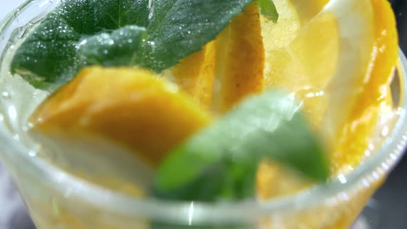 A Refreshing Soft Drink. Mojito Is Poured Into a Glass Close-up. Lemon Mint and Sparkling Water with