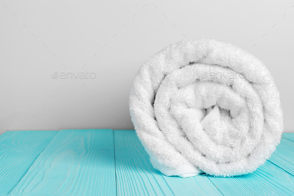 Stacked clean fluffy towels in a bathroom Stock Photo by FabrikaPhoto