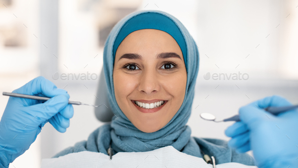Cosmetic Dentistry. Smiling Islamic Lady In Hijab Posing During Checkup In Clinic