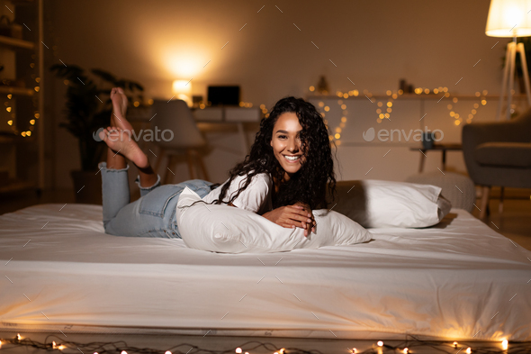 Happy Lady Lying On Stomach On Bed Relaxing At Home