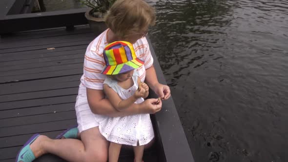 People Feed Fish in the Pond