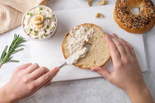 Female Hands Spreading Cashew Cheese On A Bagel Stock Photo By Krushon