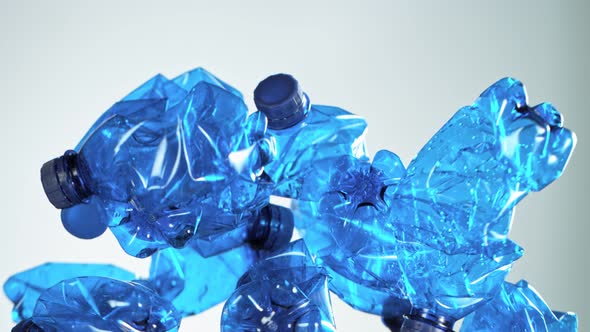 Super Slow Motion Shot of Flying Empty Plastic Bottles on Light Gradient Background at 1000Fps alt