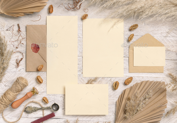 Wedding suite cards and envelope near dried plants, palm leaves and pampas grass