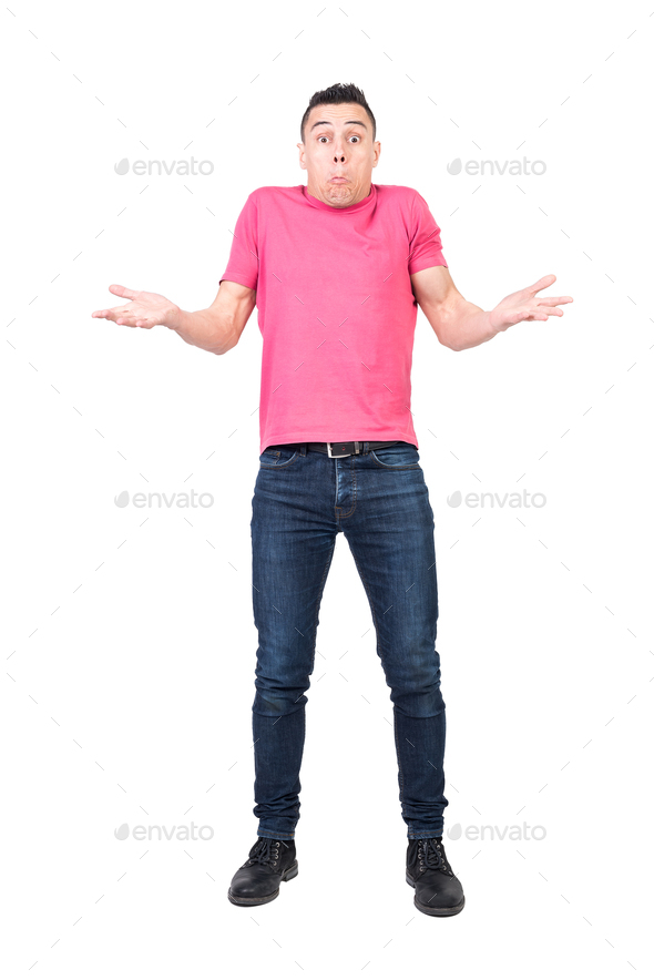 Young male shrugging shoulders and looking puzzled in studio - Stock Photo - Images