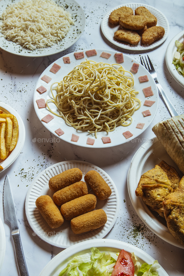 Vertical view of variety of dishes on fast food restaurant table.