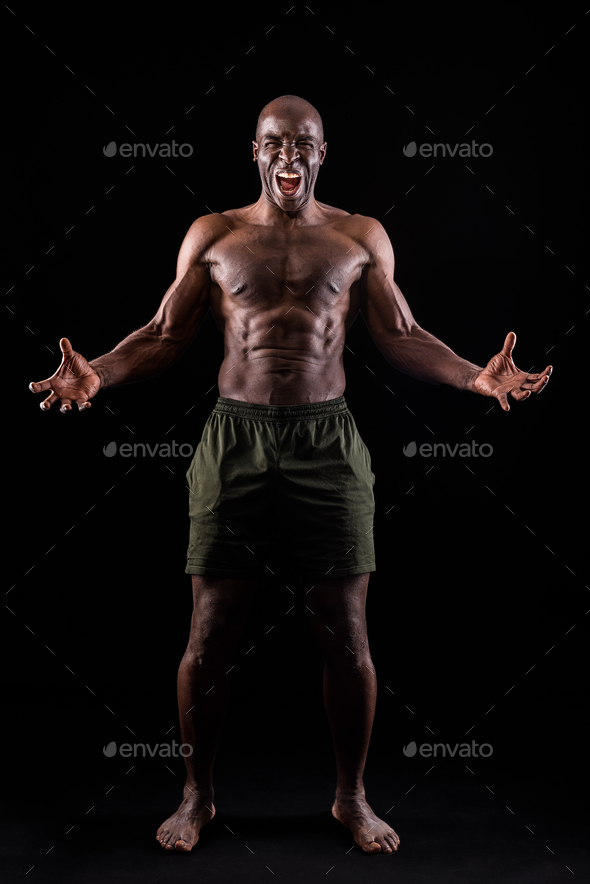 African American man facing front with hands open and shouting at camera
