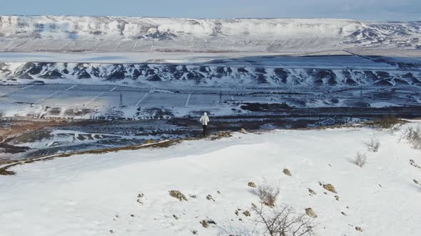A Determined Athlete Trains on a Winter Morning on a Hilltop Against the Backdrop of a Snowcovered alt
