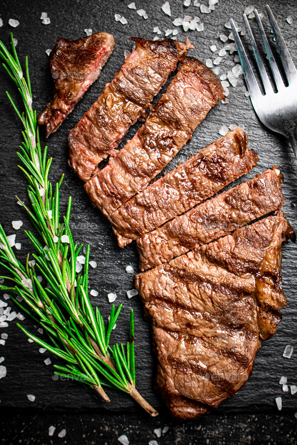 Grilled steak with a sprig of rosemary. Stock Photo by Artem_ka2
